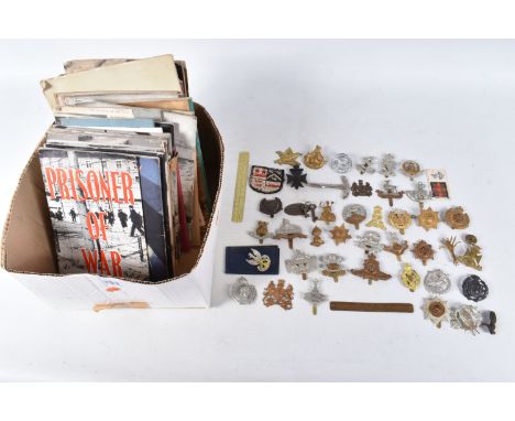 A BOX CONTAINING OVER THIRTY FIVE CAP BADGES, and an assortment soft back magazines relating to WWII, the cap badges include 
