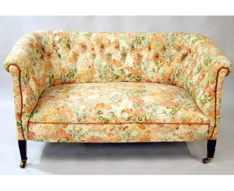 An Edwardian mahogany framed 'D' end sofa, of small proportion upholstered in (later) buttoned back floral material on square