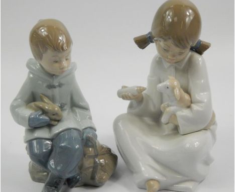 Two Nao figures, one of a young girl feeding a lamb, the other in the form of a boy with a rabbit, the largest 17cm high.