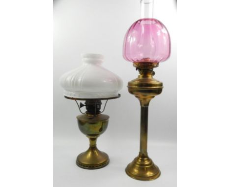 An anodised brass oil lamp, with cranberry tinted shade and another, (2).