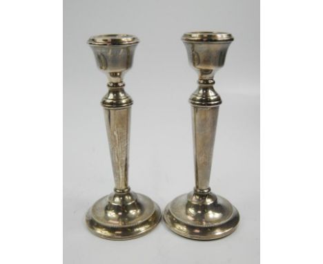 A pair of Elizabeth II silver candlesticks, with circular dish holders on tapering stems on domed part beaded feet, Birmingha