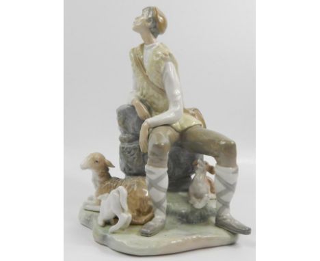 A Lladro porcelain figure group, in the form of a goat  herder with dog, goat and kid seated on a rock, 26cm high.