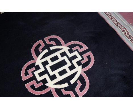 A modern Chinese style carpet, with black central centre within a pink and grey border, 340cm x 248cm.