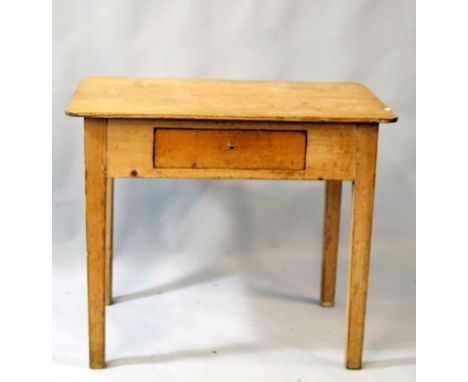 A late 19thC stripped and lightly polish light table, the oblong over hanging top raised by a frieze drawer on square block s