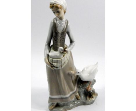 A Lladro figure of a lady and goose, with a lady carrying a gosling with goose beside, 32cm high. 