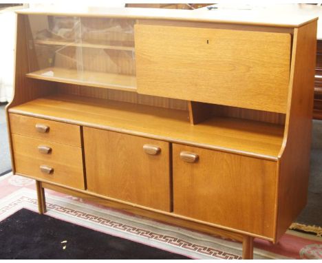 A 1970s teak retro sideboard, the upper section with glazed doors revealing a single shelf aside a hinged fall front revealin