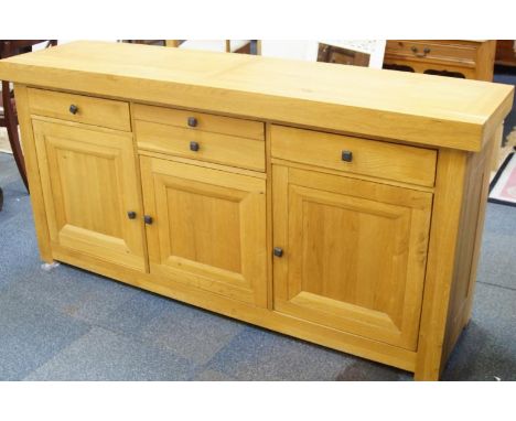 A modern light oak sideboard, with a combination of drawers and cupboards, together with a mirror back, 188cm wide.