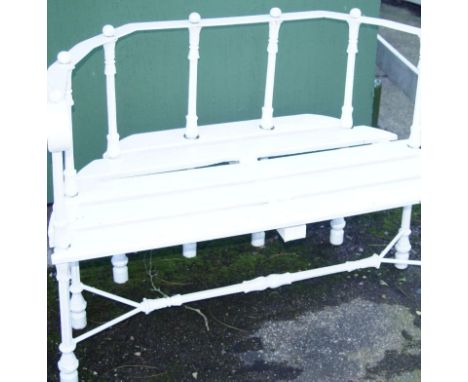 A cast iron and wooden slatted bench, of D-end outline, the scroll top roll raised on bell flower supports with a slatted sea