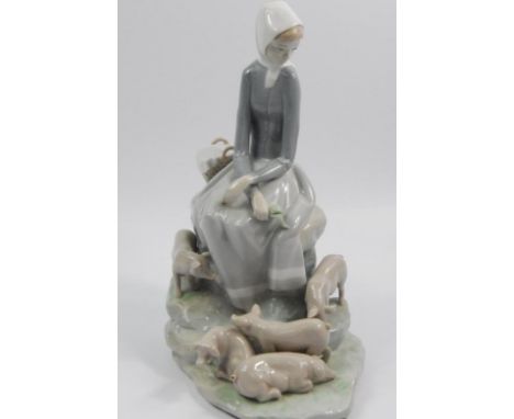A Lladro porcelain figure group, in the form of a lady with piglets, 27cm high.