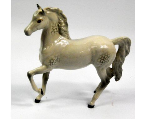 A Beswick ceramic model of a dapple grey horse, with leg raised, 17cm high.