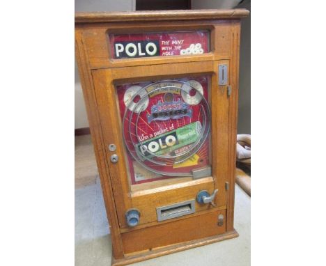 A Polo slot machine, wall mounted, in oak case with glass frieze panel, inscribed "Polo the mint with the hole", the main gla