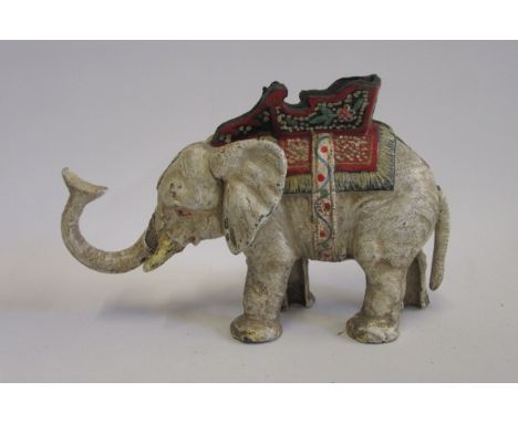 A cast iron money box in the form of an elephant with howdah, tail operates trunk to feed coins, painted, 8 1/2" long (Est. p