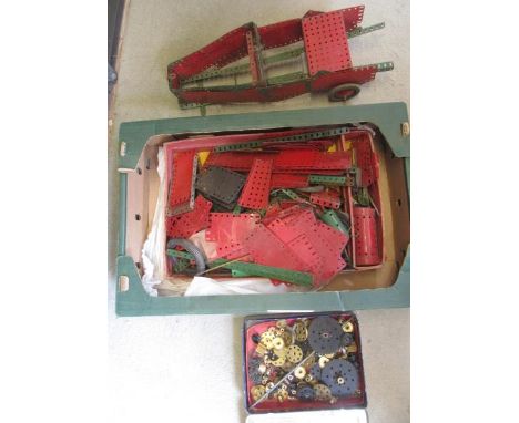 A quantity of Meccano parts including a clockwork motor, gear wheels etc, all well used, instruction booklets, and box (lid p