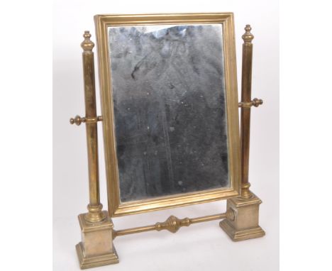 A vintage early 20th century brass swing mirror, raised on two plinth-style feet. Measuring approx. 41.5cm x 35cm.