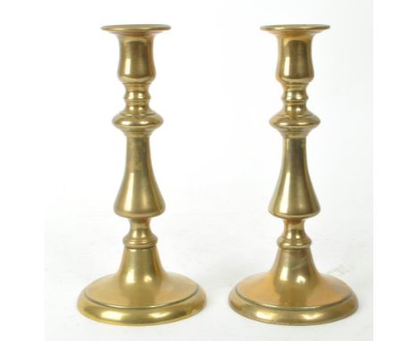 A pair of early 20th century brass candlestick / taperstick holders, measuring approx. 20cm tall. 