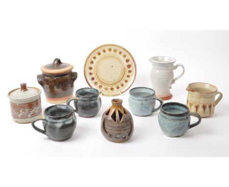 A collection of nine 20th-century studio pottery pieces and stoneware, including ceramic blue glazed mugs, two jugs, a decora