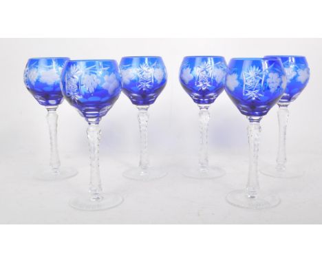 A collection of six vintage mid century cobalt blue cut crystal wine glasses, featuring a heavily cut stem, and cut grapes an