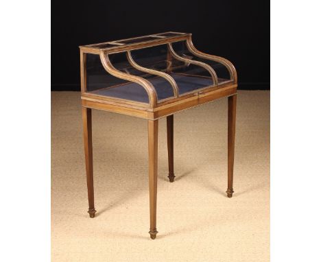 A Fine Quality 19th Century Glazed 'Piano Top' Bijouterie Cabinet. The triple panelled shaped glass top in a moulded framewor