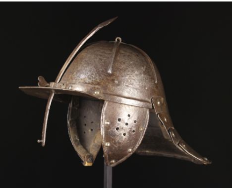A 17th Century Lobster-tailed Helmet with sliding nasal bar piercing throught the fixed peak, hinged & perforated ear flaps, 