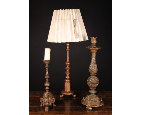 Three Turned Wooden Lamps: An elaborately decorated giltwood candle-stand with a lotus petalled socket above a wrythen fluted