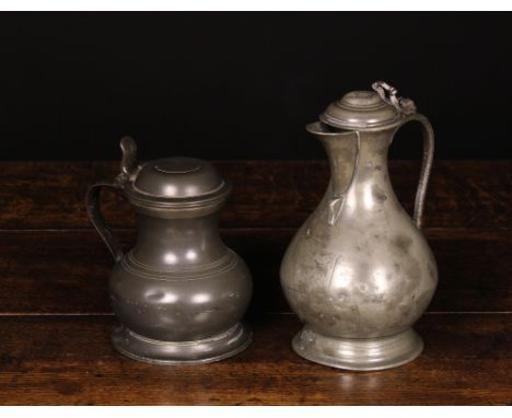 An 18th Century Bellied Wine Pitcher with engraved crest 10 ins (25 cms) high, and an antique pot bellied ring turned measure