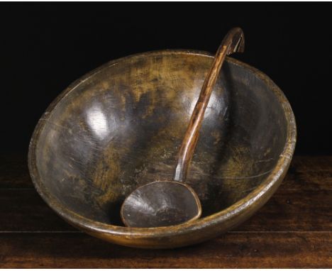 A Large 19th Century Treen Dairy Bowl; probably beechwood, and a dug-out treen ladle with hook end. The bowl 6¼ ins (1 cms) h