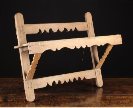 An Antique Pine Wall Hanging Rack roughly constructed from shaped rails nailed together, bearing a single shelf pierced with 