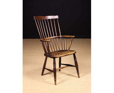 A 19th Century Comb Backed Windsor Armchair. The shaped top rail above nine long spindles piercing through a bent ash arm-bow