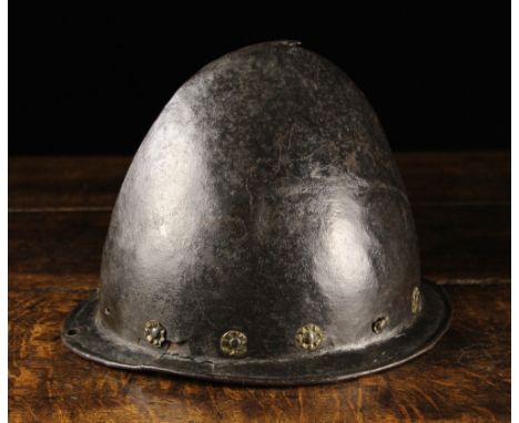 A Late 16th Century Italian Cabasset Helmet with a stalk like projection to the top and a row of decorative brass rosette stu