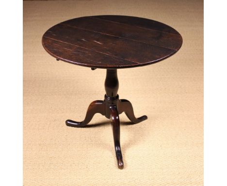 A George III English Oak Tripod Table of rich colour and patination. The circular tilt top on a boxed 'bird-cage' above a bol