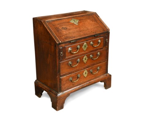 the interior fitted with an arrangement of pigeon holes and a pair of small drawers, over one short and two long drawers, on 