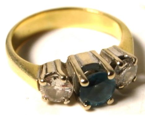 A yellow metal ring set with a central blue topaz and diamond either side, size H, approx weight 3.8g.
