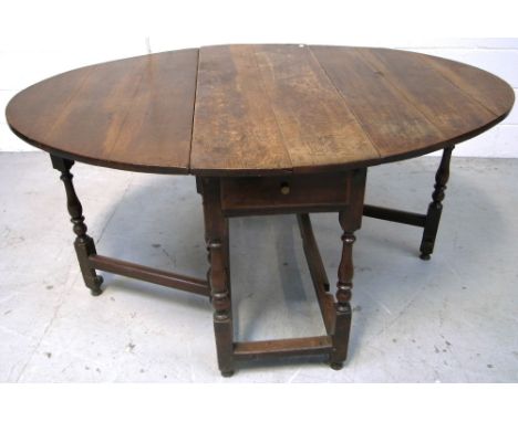 An 18th century oak gateleg table with ring turned supports terminating in block supports, width when fully extended 153cm.