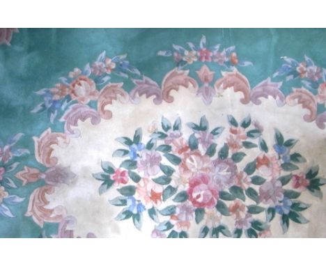 A large sage green ground Oriental rug with central floral motif and border, 320 x 240cm.