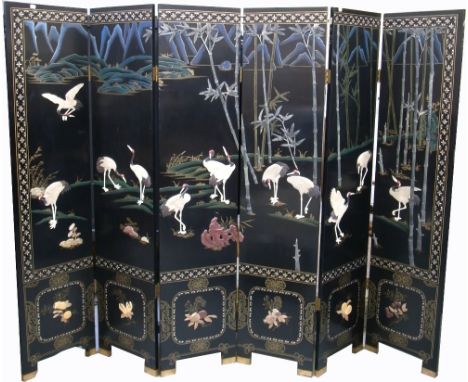 A 20th century Oriental six panel ebonised screen, hand painted and inlaid with mother of pearl and soapstone with cranes, wa