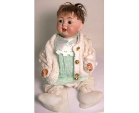 A late 19th early 20th century bisque head doll marked CP to the back of the neck, with associated clothing, height 50cm.