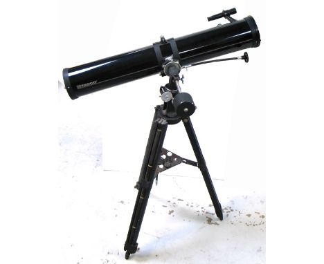 A Tasco 114mm diameter reflecting Newtonian telescope complete with tripod and equatorial mount.