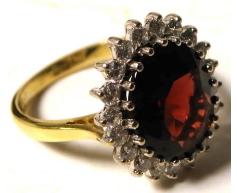 An 18ct gold ring set with large central garnet and diamond surround, size P, approx weight 6g.