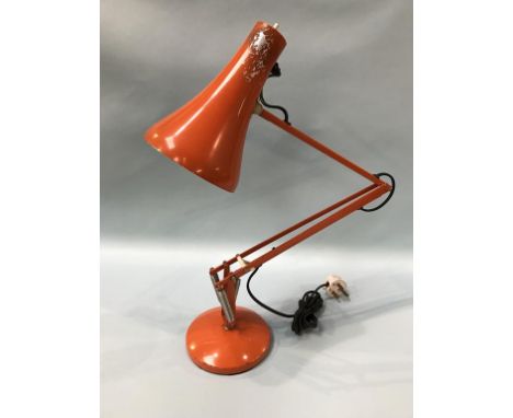 An orange angle poise Lighting Ltd lamp