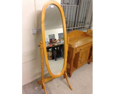 A light wood oval cheval mirror