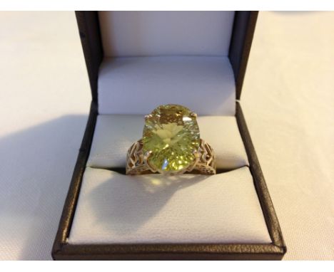Hallmarked 9ct gold ring set with a large oval citrine nicely cut with many facets. Pierced mounts with heart design, size ap
