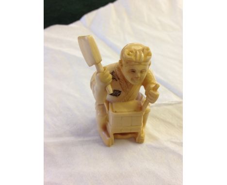 A signed netsuke of a carpenter with axe & chisel.