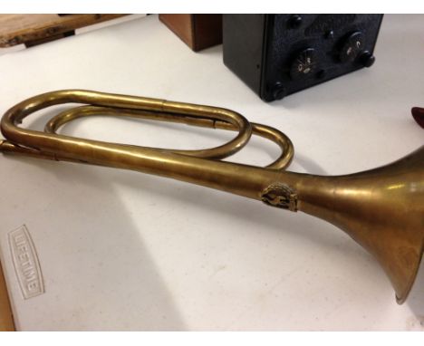 A brass bugle with the crest of the Uganda Police service. No mouthpiece.
