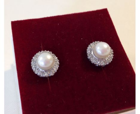 A pair of vintage pearl and diamond stud earrings - approx 20 diamonds set around a single pearl. Not hallmarked - tests as 1