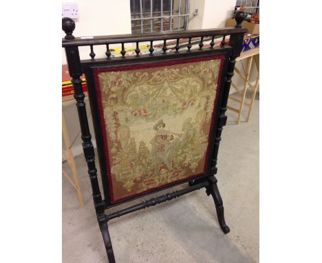 A large Victorian tapestry fire screen with turned wood supports and stretcher and galleried top.