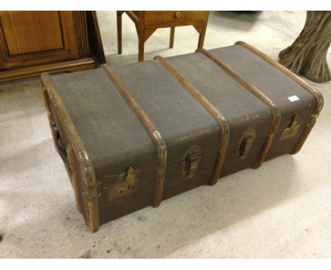 A large wooden banded travelling trunk with interior shelf.