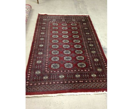 A vintage red patterned wool rug/carpet. Approx 190 x 127cm - fringed.