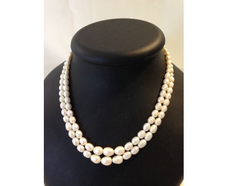 Double string freshwater pearl necklace, pearls of oval shape with graduated sizes.