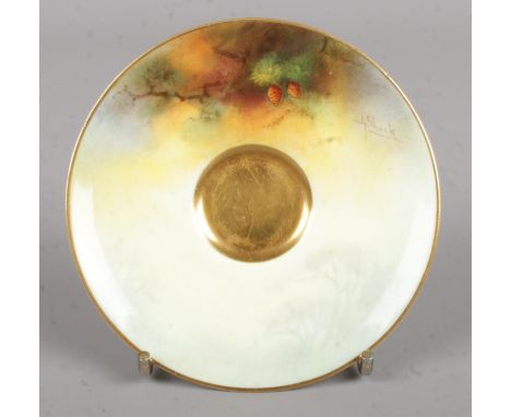 A Royal Worcester porcelain saucer with hand painted decoration, signed A Shuck. 10cm diameter.  