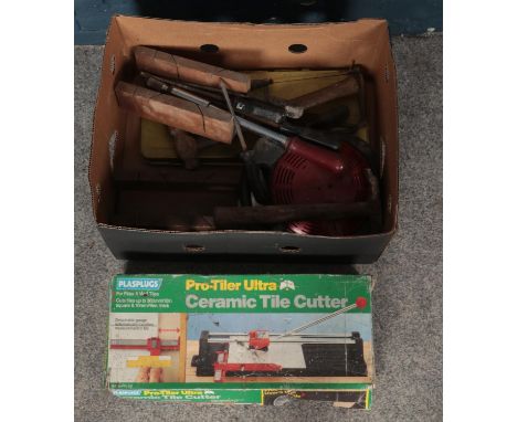 A box of tools. Including ceramic tile cutter, hammers, screwdrivers, etc.  